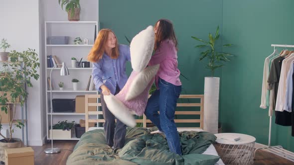 Happy Carefree Girls Students Roommates Sit at Home Fight Pillows alt