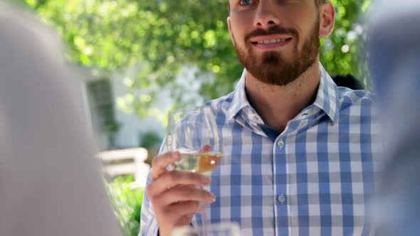 Man interacting with friends while having wine alt