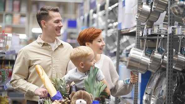 Portrait of Friendly Family Choosing Dishes Pans and Pots Making Purchase