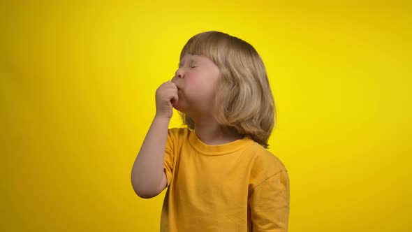 A Cute Little Girl with Short Hair is Blowing in a Whistle with Closed Eyes alt