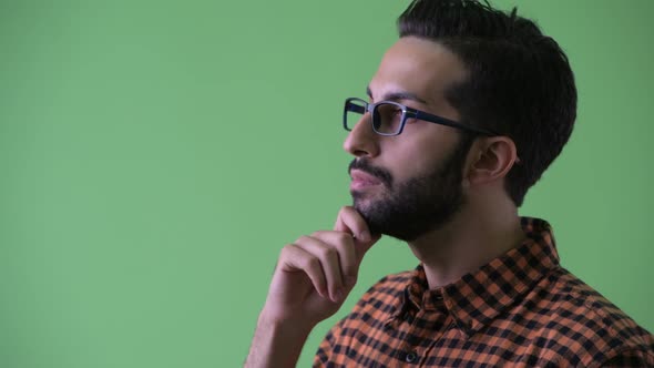 Closeup Profile View of Happy Young Bearded Persian Hipster Man Thinking alt