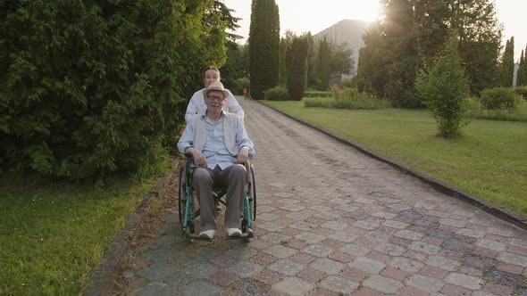 Nurse Walks Her Old Patient in the Park alt