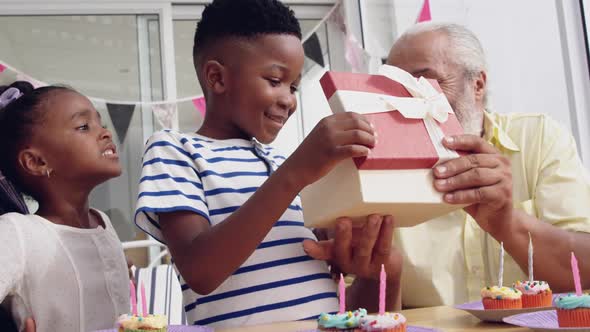 Mature couple enjoying time with their grandchildren alt