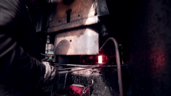 Worker Operates With Automated Metalworking Machine At a Metal Forging Factory. alt