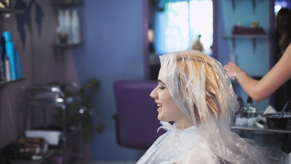 Stylist Hairdresser Does a Professional Paint On The Hair Of His Client. alt