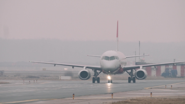 The Superjet 100 Moving On a Taxiway In The Airport In a Rainy Day.  alt