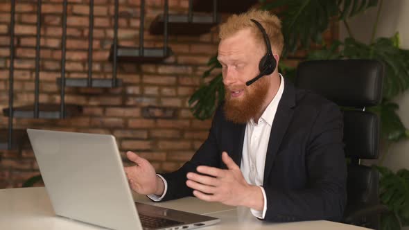 Redhead Businessman in Wireless Headset Device Communicating with Colleagues alt