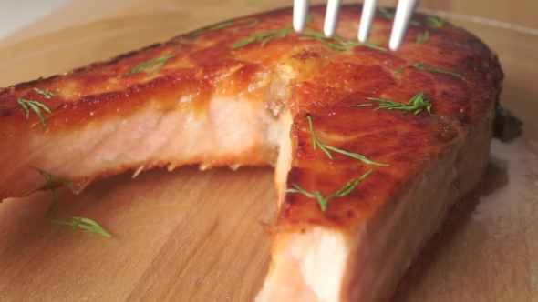 Taking a Piece Of Freshly Cooked Salmon Steak With a Fork alt