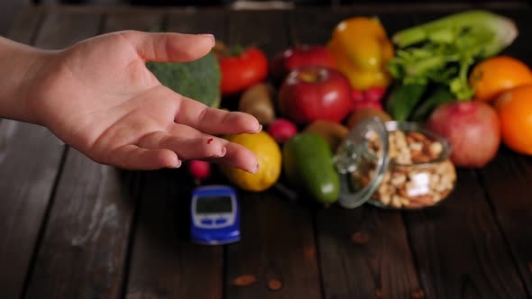 Woman with Diabetes Measuring Blood Sugar Level on the Background of Fruits alt