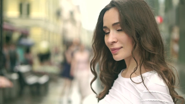 Beautiful Young Caucasian Brunette Girl Smiling At Camera Against Blurred Street alt