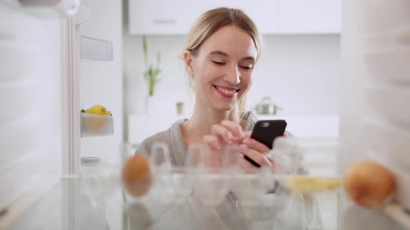 Hungry woman opening fridge looking inside searching for food, but the problem can be solved