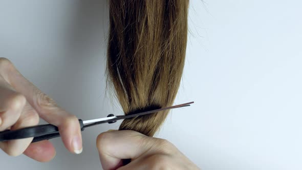 Upset Woman Cuts Her Long Straight Hair with Scissors alt
