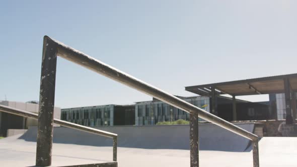 Low section of caucasian man riding and jumping on skateboard on sunny day alt