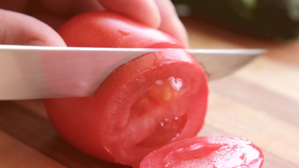 Sliced Fresh Tomato With Knife On Wooden Plate