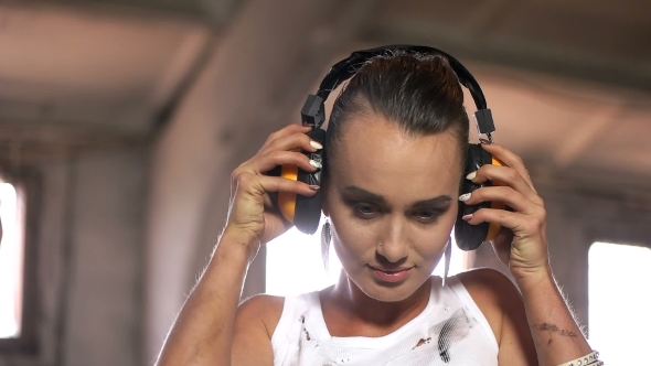 Young Woman Puts On Construction Headphones
