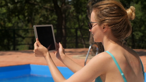 Blonde In Sunglasses Is Sitting Near Swimming Pool And Communicating
