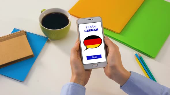 Learn German Application on Cellphone in Persons Hands, Studying Language Online alt