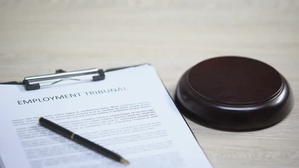 Employment Tribunal Document on Table, Gavel Striking on Sound Block, Dispute alt