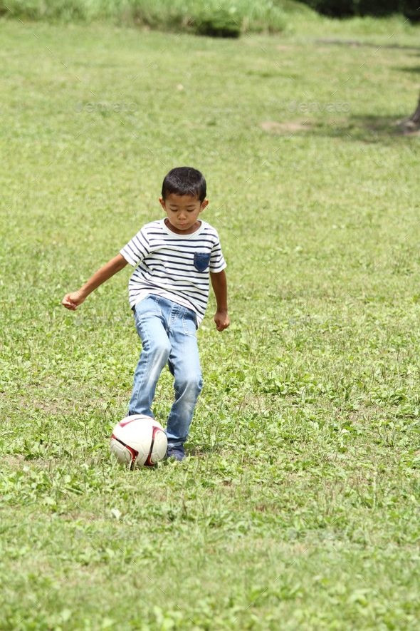 Japanese boy playing with soccer ball (first grade at elementary school)