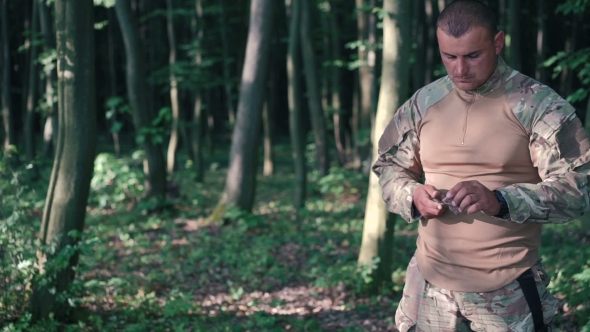 Military Sharpen Knife With Bilestone In The Forest.  alt