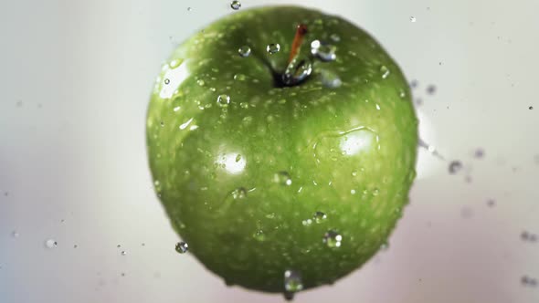 Flying of Green Apple in White Kitchen Background in Slow Motion alt