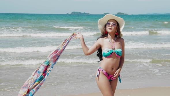 Sexy Bikini woman with scarf unveiling walking on a tropical beach. Concept freedom, Lifestyle alt