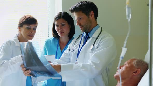 Doctors and nurse discussing x-ray alt