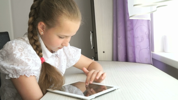 Schoolgirl Uses a Digital Tablet Computer At Home