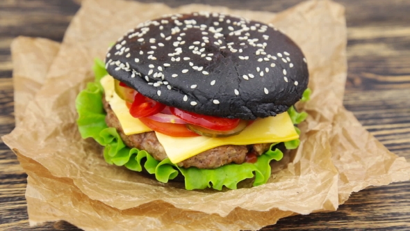 Black Burger On Wooden Table alt