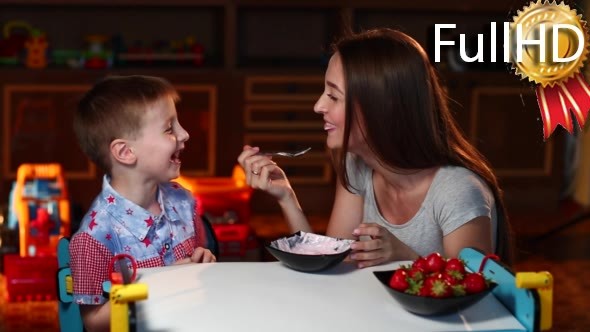 Mother Feeds the Son With a Spoon