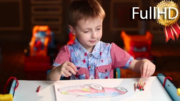 Boy Paints the Car With Crayons Sitting at Table