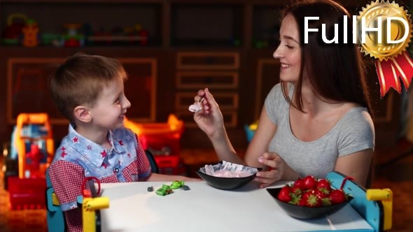 Mother Feeds the Son With a Spoon