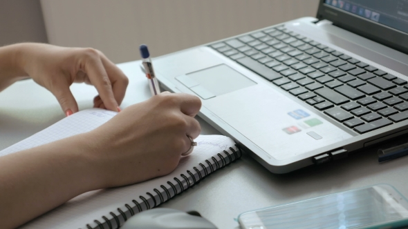 Female Types And Takes Notes In Notebook alt