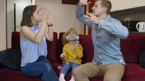 Child Girl Trying To Be Distracted and Not Hear Quarrels Between Parents at Home. Family Problems alt