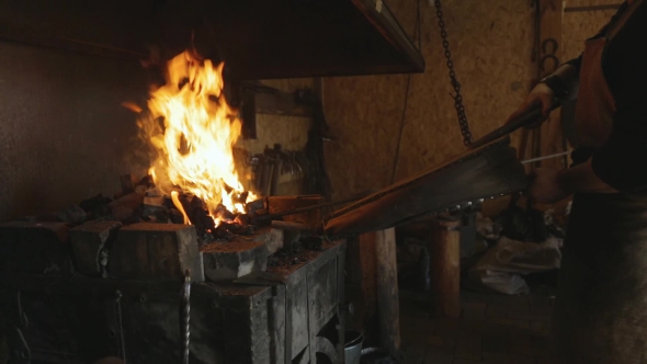 Blacksmith Lit Horn Foment Fire With Leather Bellows. alt