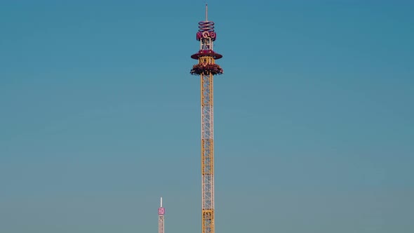 A rotating chair swing ride carousel with teenagers enjoying the ride in a amusement park. alt