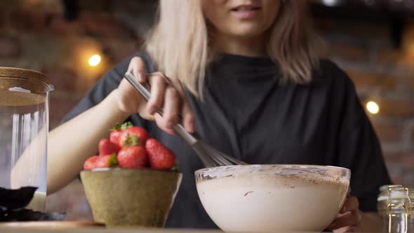 Woman Adds Cocoa Powder Into Bowl with Milk