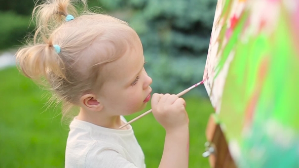 Little Girl Draws On An Easel