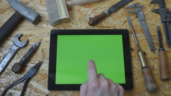 Male Hand Of Artisan Craftsman Using Tablet Pc With Green Screen In Workshop. alt