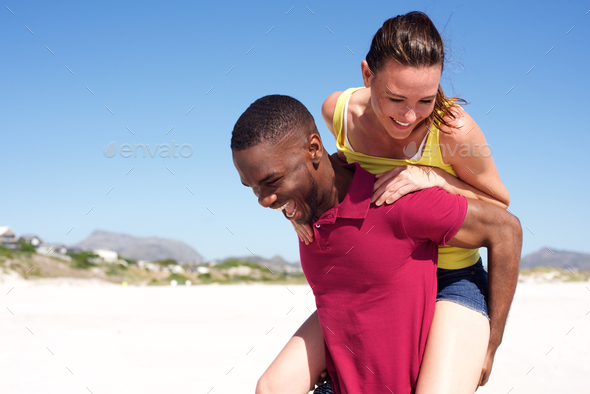 Man carrying woman on back at the beach