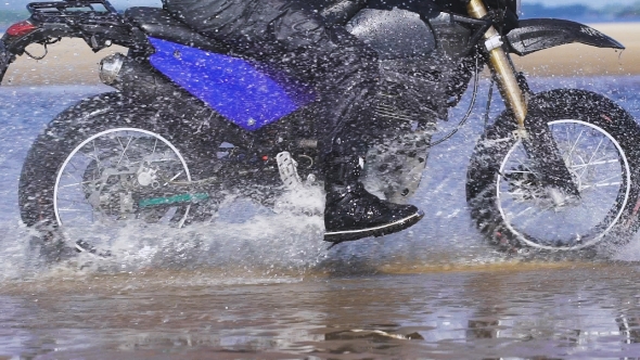 Extreme Driving a Motorcycle. A Skilled Biker Riding on the Edge of Water alt
