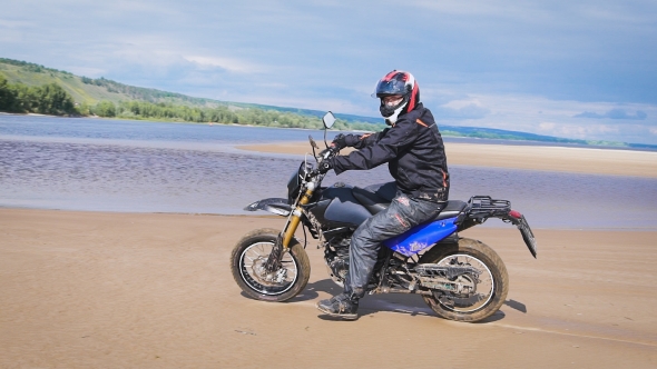 The Feeling Of Freedom And Moto Aesthetics. Motorcyclist Riding On His Bike On Sandy Beach. alt