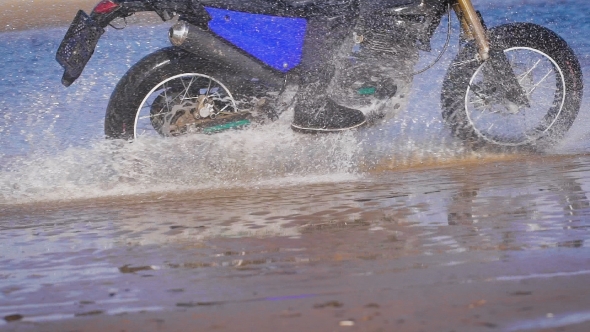 Extreme Driving a Motorcycle. A Skilled Biker Riding On The Edge Of Water alt