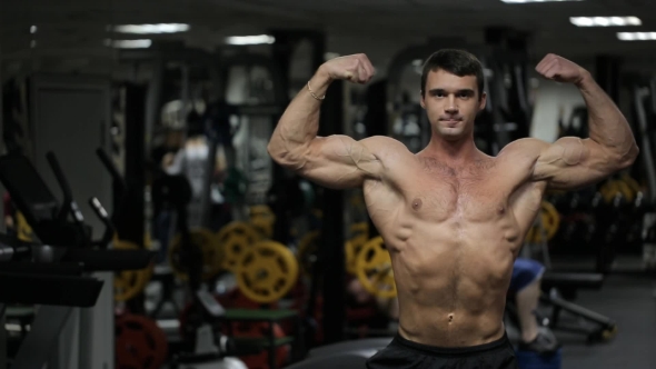 Male Athlete With an Athletic Physique, Posing in  the Gym.