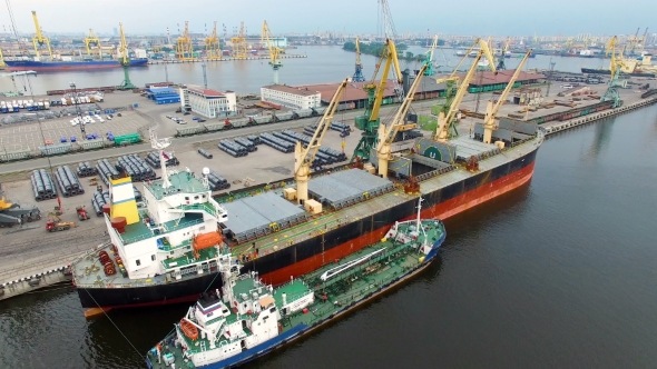 aerial view of cargo ship in the port which is loaded in the holds alt