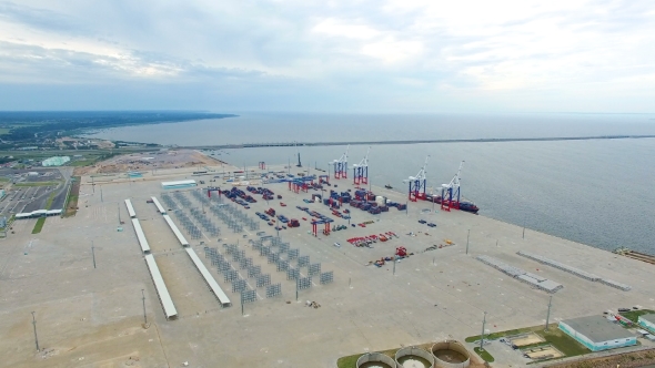 Aerial view of a seaport with cranes, ships, containers and cargo alt