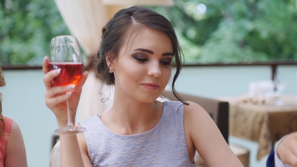 Girl with friends drinking wine in a restaurant