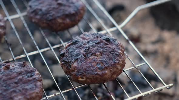 Beef Burgers Cutlets are Roasting on the Charcoal Barbecue Grill alt