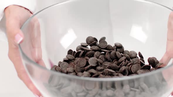 Chocolatier Shaking Chocolate Couverture Callets in Glass Bowl Close Up Slow Mo