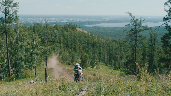 Racer on a Motorcycle Rides to Mountain
